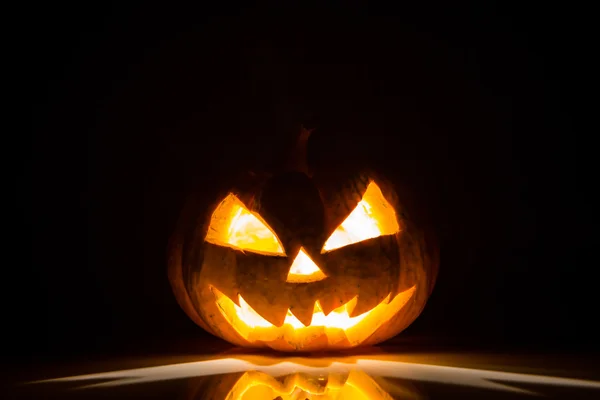Halloween assustador rosto abóbora no fundo preto — Fotografia de Stock