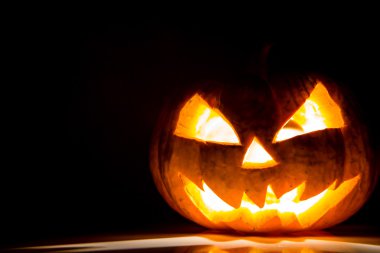 siyah arka plan üzerinde Halloween korkunç yüzünü kabak