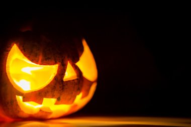 siyah arka plan üzerinde Halloween korkunç yüzünü kabak