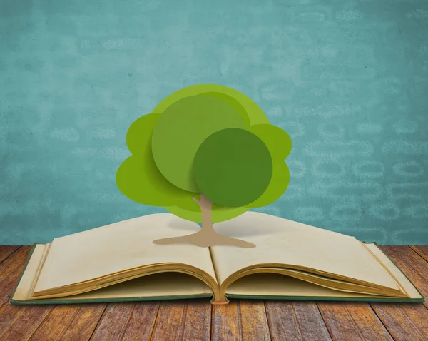 Paper cut of tree on old book — Stock Photo, Image