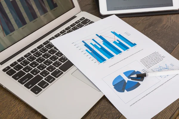 Financiële kaarten op tafel met tablet en laptop — Stockfoto