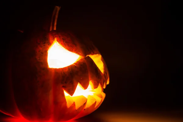 Halloween dýně děsivá tvář na černém pozadí — Stock fotografie