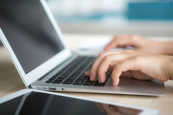 Primer plano de la mujer de negocios escribiendo a mano en el teclado del ordenador portátil con mo —  Fotos de Stock