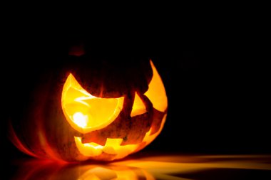 siyah arka plan üzerinde Halloween korkunç yüzünü kabak