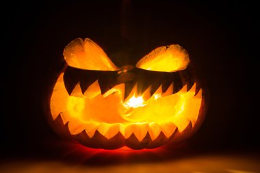 siyah arka plan üzerinde Halloween korkunç yüzünü kabak
