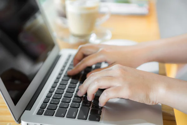 Close-up van zakelijke vrouw hand te typen op het toetsenbord van de laptop en cof — Stockfoto