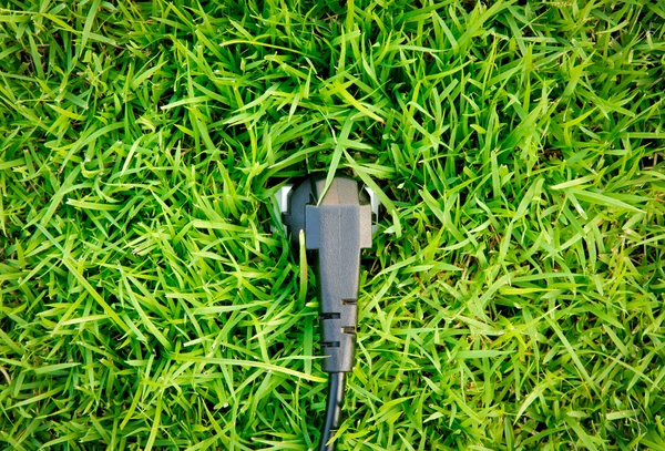 Energy concept outlet in fresh spring green grass — Stock Photo, Image