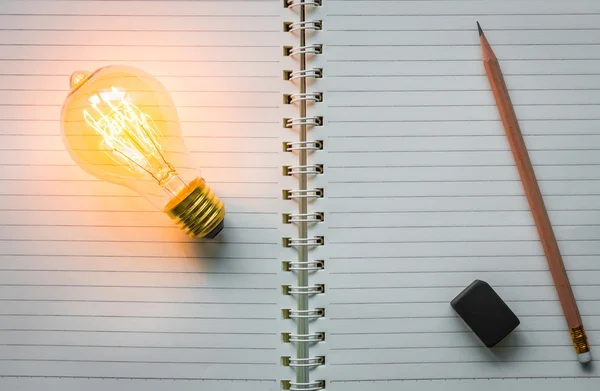 Note book and light bulb — Stock Photo, Image