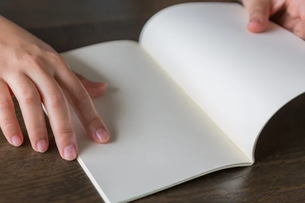 Hands open book on wood table — Stock Photo, Image