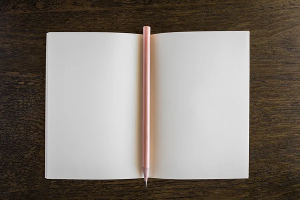 Cuaderno con lápiz en un escritorio de madera — Foto de Stock
