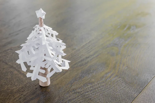 Paper snowflakes christmas tree on wood table — Stock Photo, Image