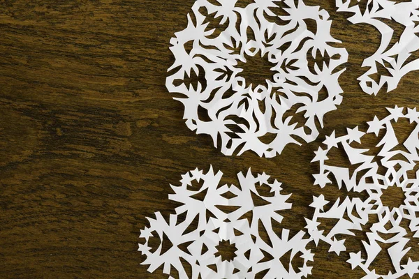 White paper christmas snowflake on a wood background — Stock Photo, Image