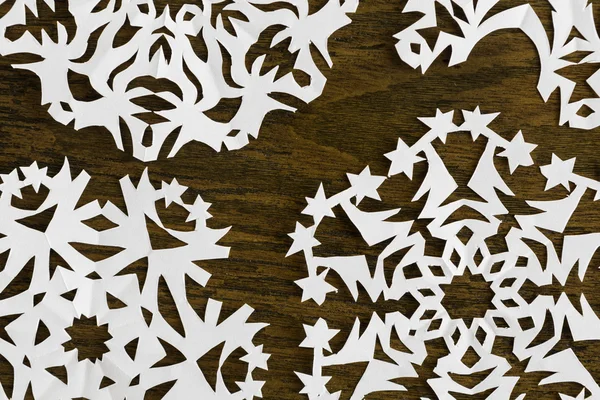 White paper christmas snowflake on a wood background — Stock Photo, Image