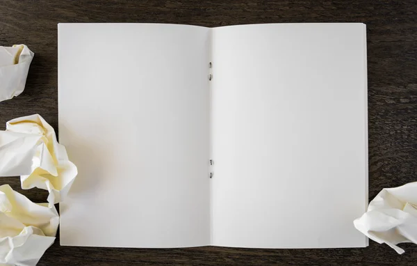 Livro de notas com papel amassado em uma mesa de madeira — Fotografia de Stock