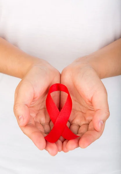 Mani femminili con il nastro rosso di sensibilizzazione all'AIDS — Foto Stock