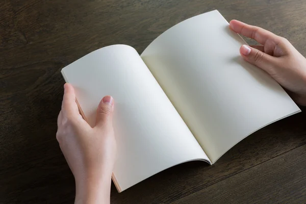 Ahşap masa üzerinde eller açık kitap — Stok fotoğraf