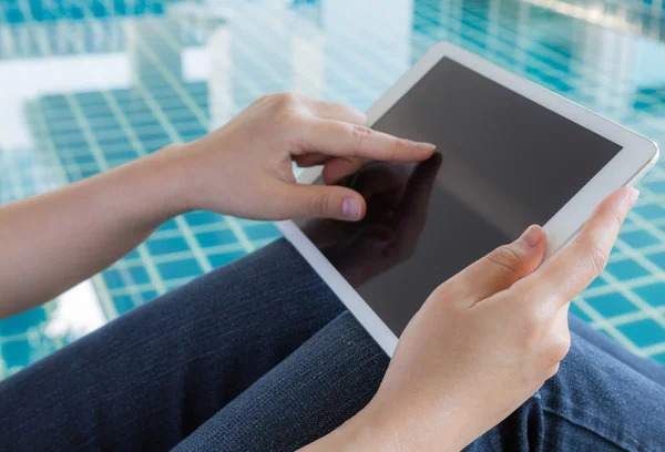 Mujer trabajando con la tableta sentada en la piscina —  Fotos de Stock