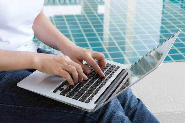 Woman working with tablet sitting at swimming pool — Stock Photo, Image