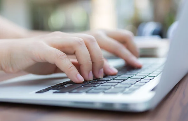 Primo piano della mano della donna d'affari che digita sulla tastiera del computer portatile — Foto Stock