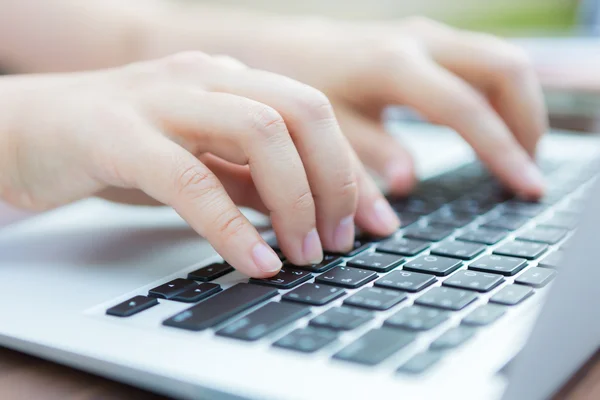 Primer plano de la mujer de negocios escribiendo a mano en el teclado del ordenador portátil Imágenes de stock libres de derechos