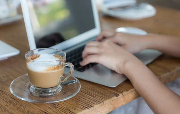 Close-up van koffie en hand laptop toetsenbord — Stockfoto