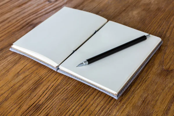 Boek met potlood op een houten bureau — Stockfoto