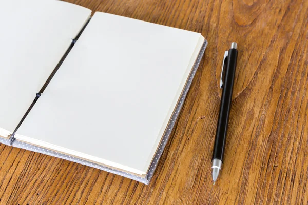 Book with pencil on a wooden desk — Stock Photo, Image