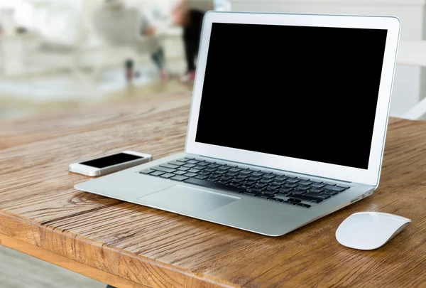 Laptop com telefone inteligente na mesa de madeira — Fotografia de Stock