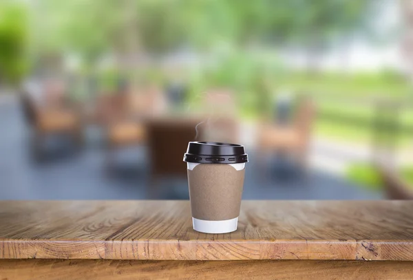 Papper kopp kaffe på trä bord på restaurang — Stockfoto