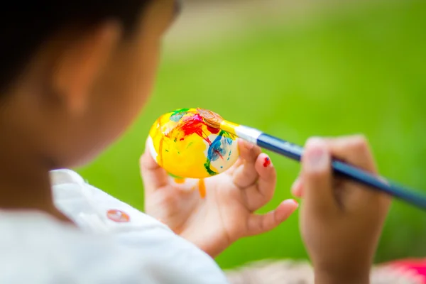 Niño pintando huevo de Pascua con pincel —  Fotos de Stock