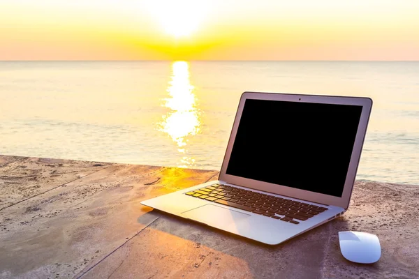 Laptop na mesa ao pôr-do-sol do mar na hora de verão — Fotografia de Stock