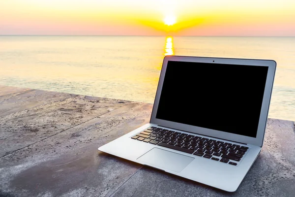 Laptop na mesa ao pôr-do-sol do mar na hora de verão — Fotografia de Stock