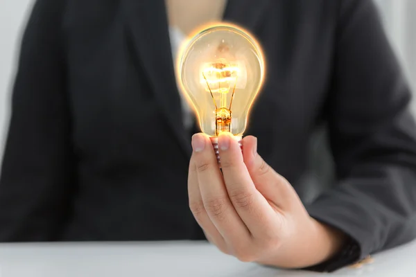 Empresários segurando lâmpada — Fotografia de Stock