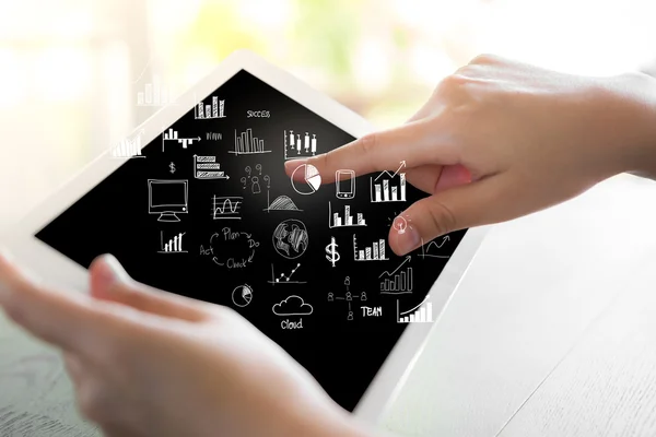 Woman hand hold white tablet with graph and chart symbols — Stock Photo, Image