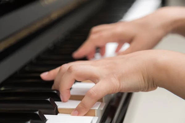 Närbild av kvinnor händer spelar piano — Stockfoto