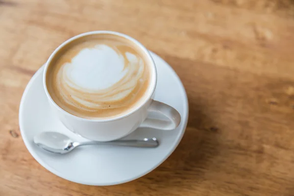 Кава в білій чашці на дерев'яному столі — стокове фото