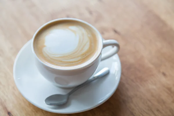 Kahvi valkoinen kuppi puupöydällä — kuvapankkivalokuva