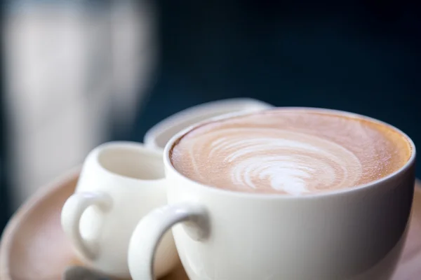 Kuuma latte art kahvi pöydällä — kuvapankkivalokuva