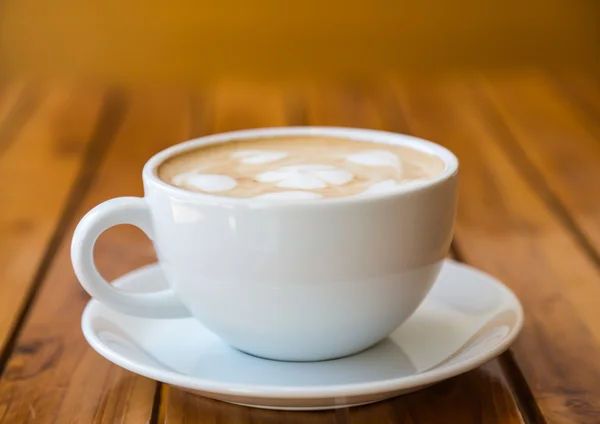 Kuppi kahvia sydämen kuvio valkoinen kuppi puupöydällä — kuvapankkivalokuva