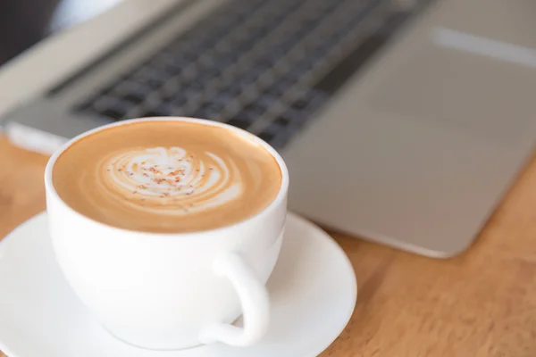 Laptop met een koffiekopje op oude houten tafel (gefilterde afbeelding proc — Stockfoto