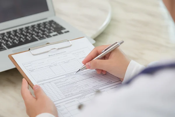 Doctor writing on prescription — Stock Photo, Image