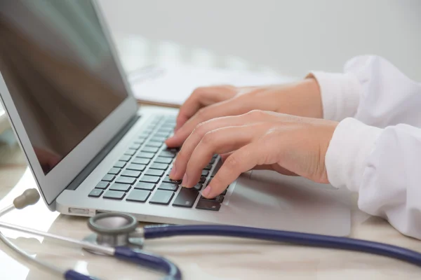 Médico digitando no teclado do laptop — Fotografia de Stock