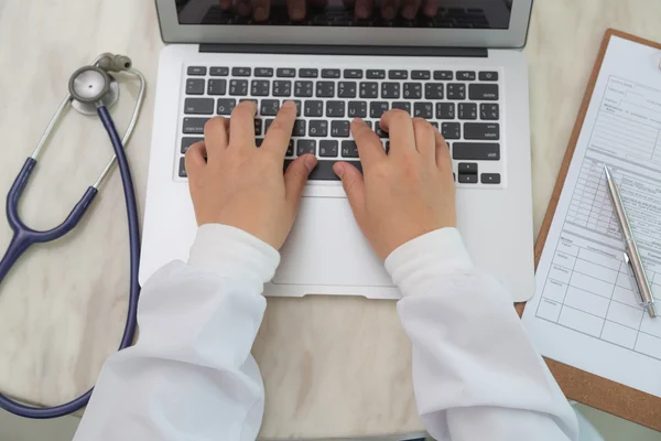 Médico manos tecleando en teclado portátil —  Fotos de Stock