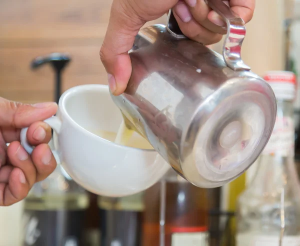 Milch gießen, um Kaffee zu mischen — Stockfoto