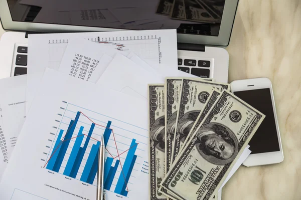 Financial charts on the table with laptop — Stock Photo, Image