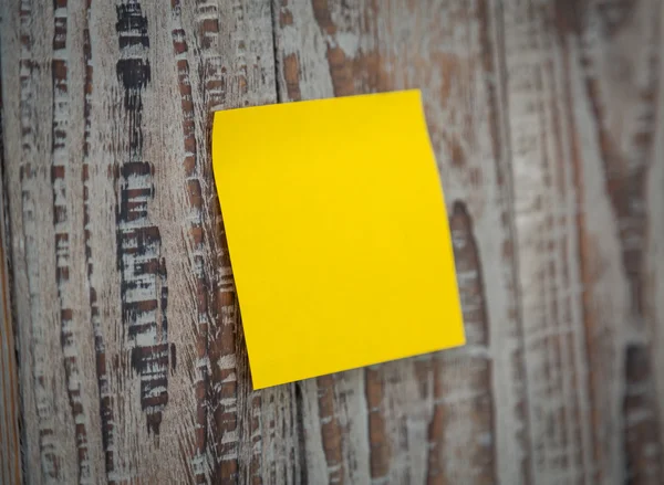 Yellow sticky note on wooden board — Stock Photo, Image