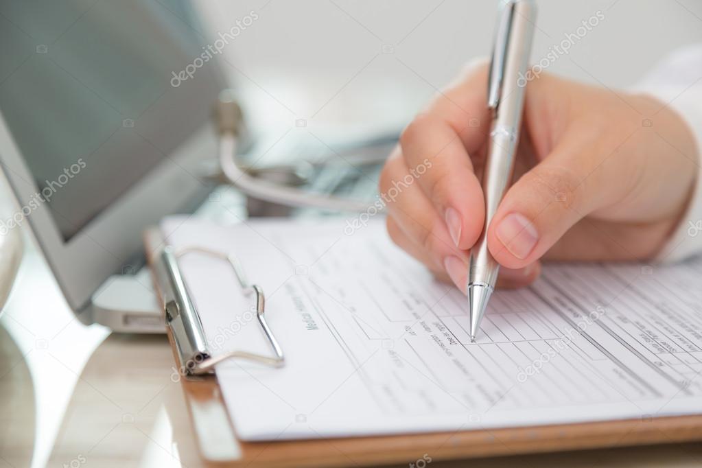 doctor writing on prescription