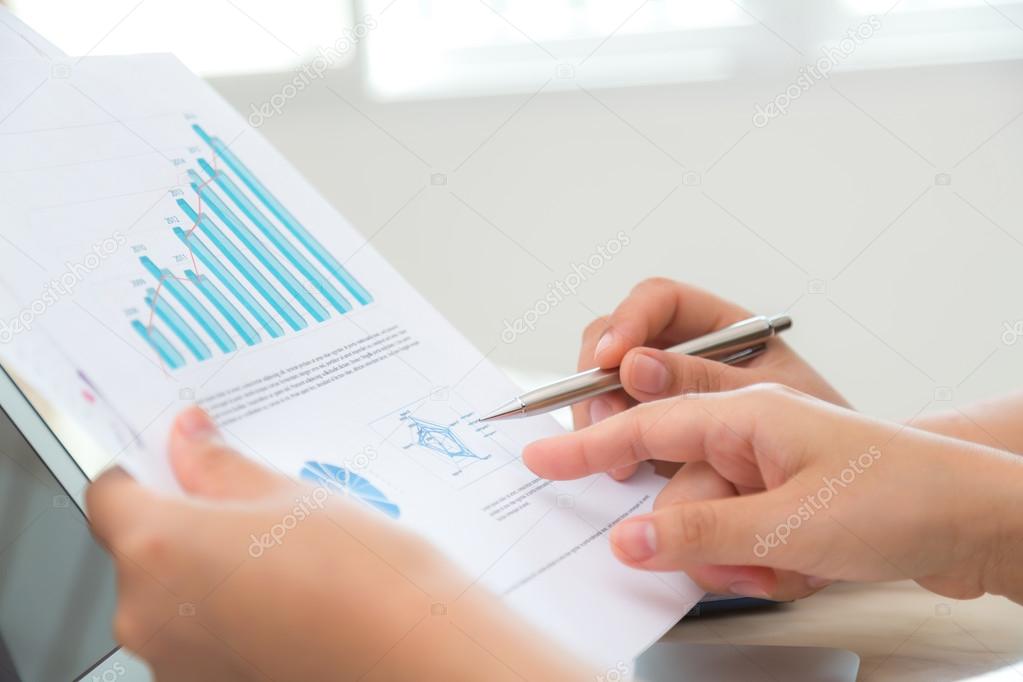Group of business people pointing at business document