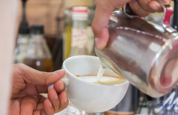 Derramando leite para misturar café — Fotografia de Stock