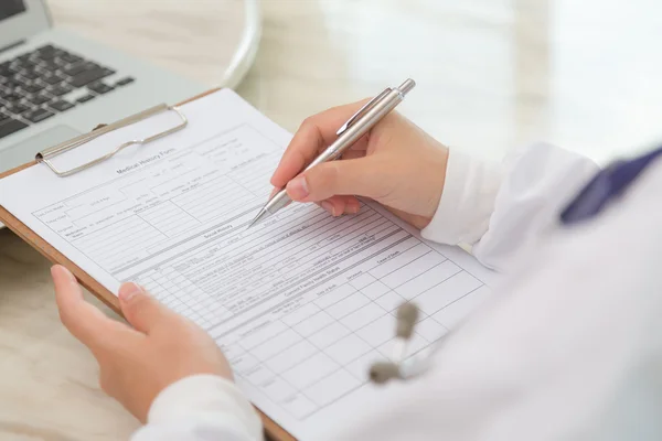 Hand of doctor writing on prescription — Stock Photo, Image